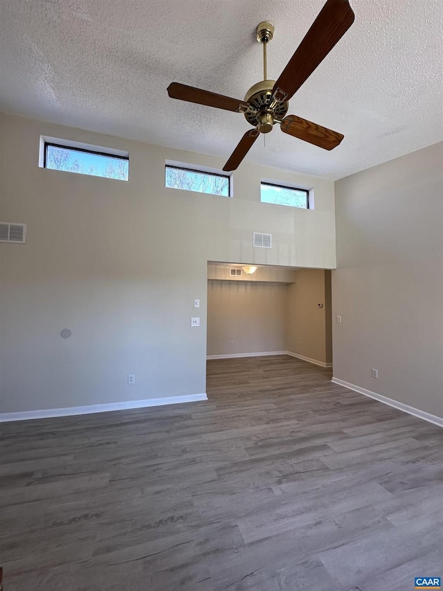 spare room featuring a wealth of natural light, visible vents, and wood finished floors