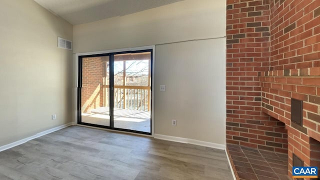 unfurnished room with baseboards, visible vents, and wood finished floors