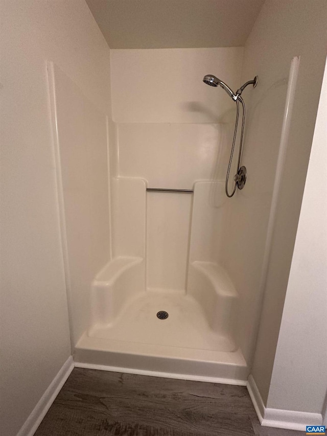 full bathroom with a shower and baseboards