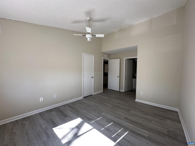 unfurnished bedroom featuring lofted ceiling, a textured ceiling, baseboards, and wood finished floors