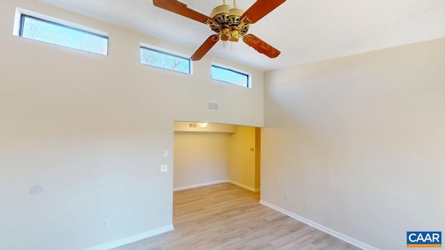 unfurnished room with ceiling fan, light wood-type flooring, visible vents, and baseboards