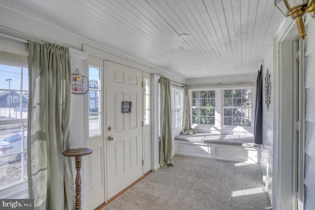 foyer entrance featuring carpet floors and wood ceiling