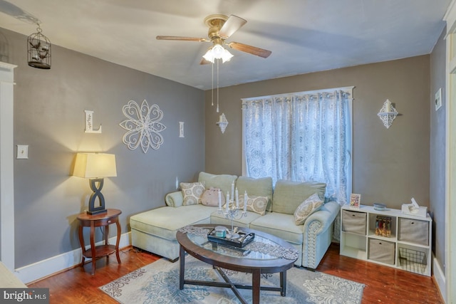 living area with ceiling fan, baseboards, and wood finished floors