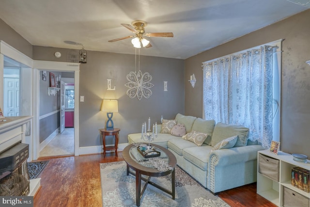 living area with ceiling fan, baseboards, and wood finished floors