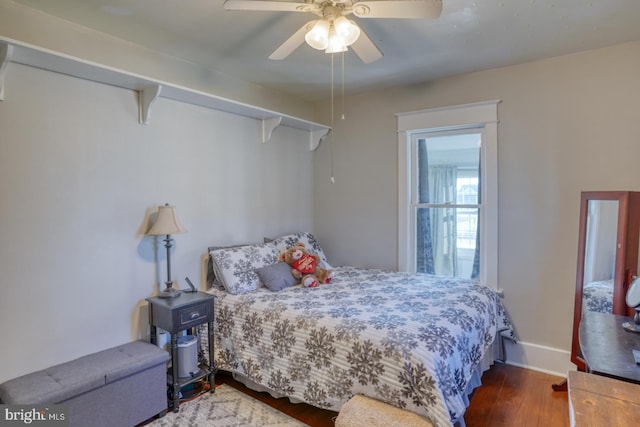 bedroom featuring a ceiling fan, baseboards, and wood finished floors