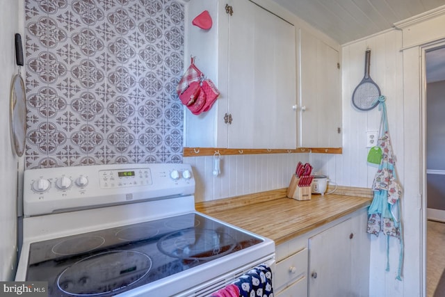 kitchen featuring white cabinets, light countertops, and white range with electric cooktop