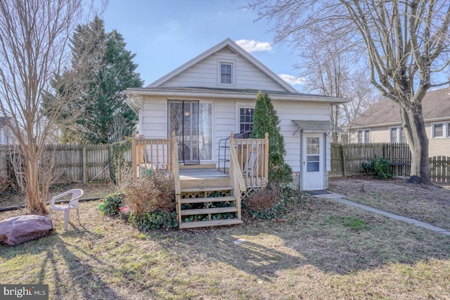 rear view of house featuring fence and a wooden deck