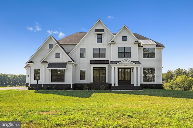 modern farmhouse style home featuring metal roof, a standing seam roof, french doors, a front lawn, and board and batten siding