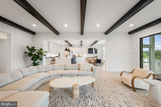 living room featuring recessed lighting, beamed ceiling, and light wood-style flooring