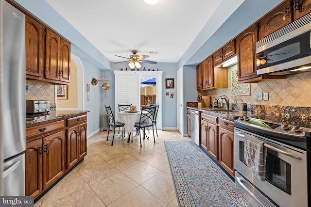 kitchen with light tile patterned floors, visible vents, dark stone counters, appliances with stainless steel finishes, and a sink