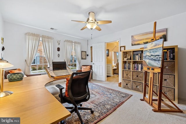 home office featuring a ceiling fan, visible vents, and carpet floors