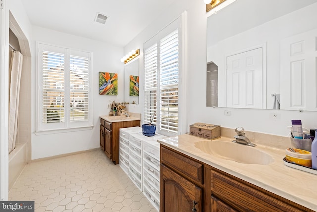 full bath featuring tile patterned flooring, plenty of natural light, vanity, and visible vents