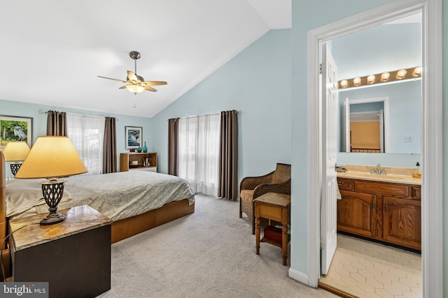 bedroom with vaulted ceiling, multiple windows, a sink, and ensuite bath