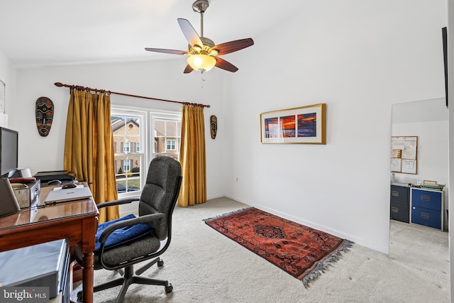 office featuring lofted ceiling, ceiling fan, baseboards, and light colored carpet