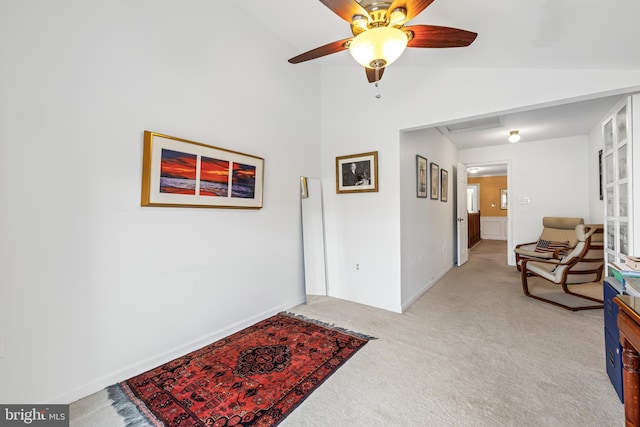 interior space with vaulted ceiling, baseboards, and light colored carpet