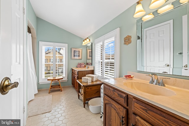 bathroom with lofted ceiling, a healthy amount of sunlight, vanity, and tile patterned floors