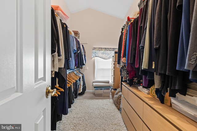 walk in closet featuring light carpet and vaulted ceiling