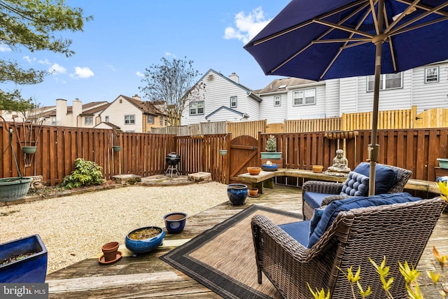 wooden deck featuring a gate, outdoor lounge area, fence, and a residential view