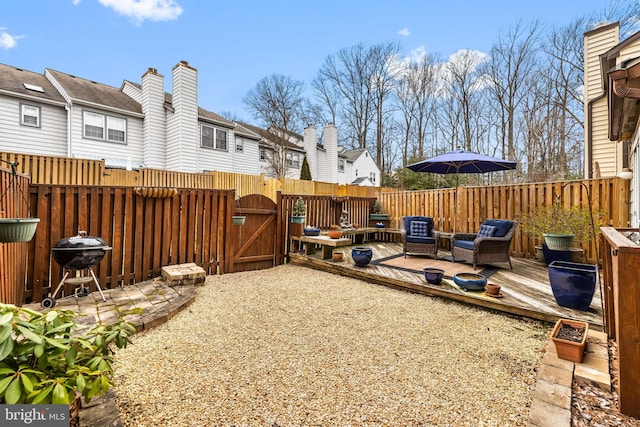 view of yard featuring an outdoor living space, a gate, fence, and a deck