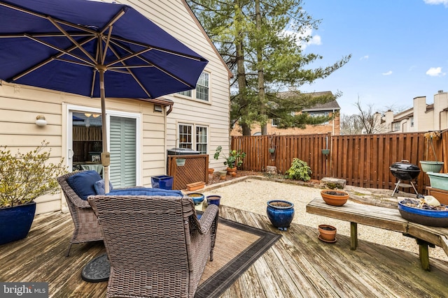 wooden terrace featuring fence private yard and a grill