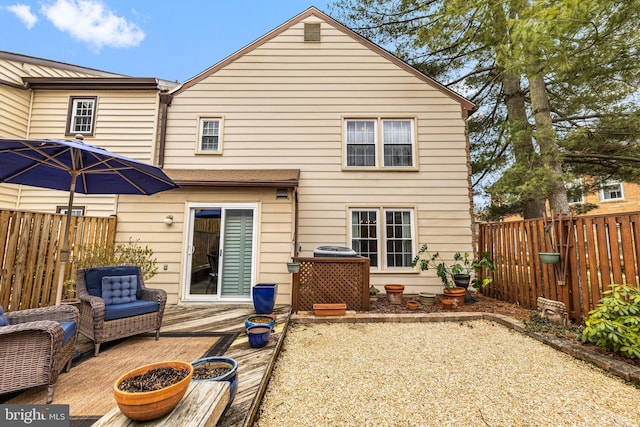 back of property with a fenced backyard and a wooden deck