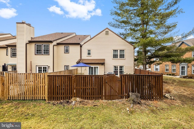 rear view of property featuring fence