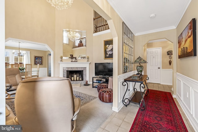 entryway featuring arched walkways, crown molding, and a notable chandelier