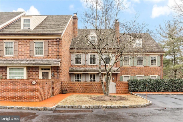 multi unit property featuring brick siding and a chimney