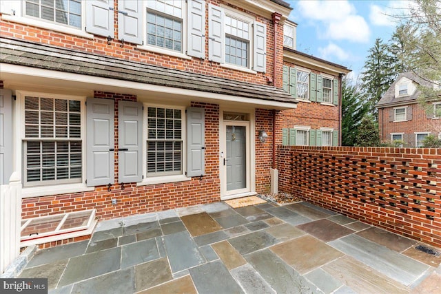 view of front of house with a patio and brick siding