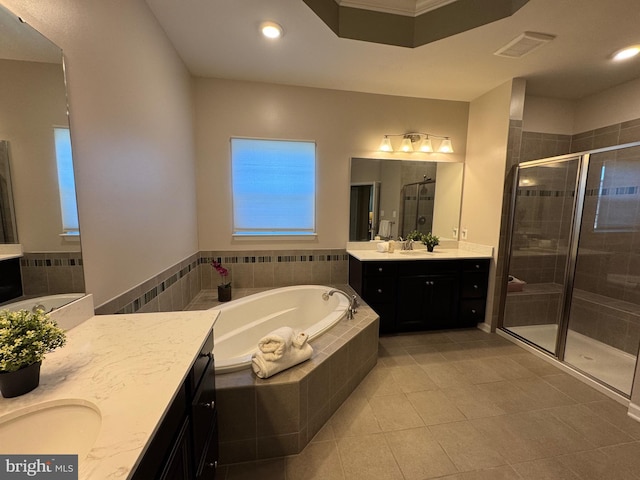 full bath featuring two vanities, visible vents, a garden tub, and a shower stall