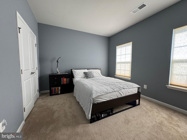 carpeted bedroom featuring visible vents and baseboards