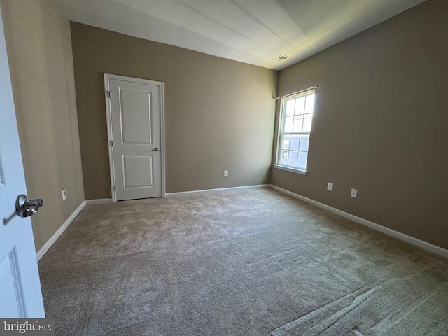 unfurnished room featuring carpet, visible vents, and baseboards