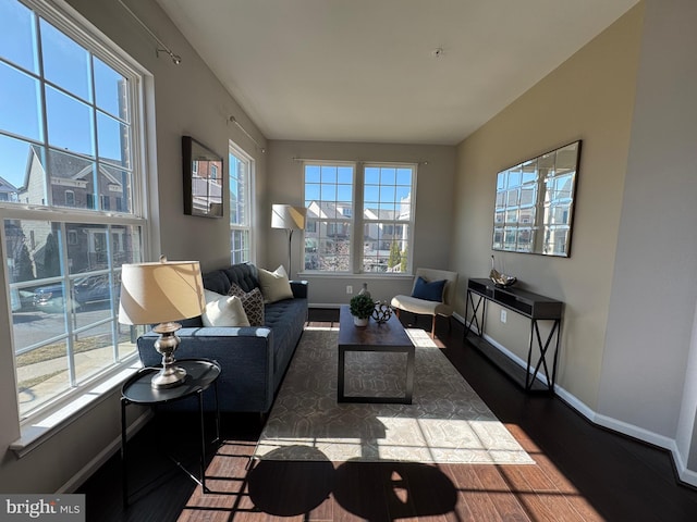 living area with plenty of natural light, wood finished floors, and baseboards