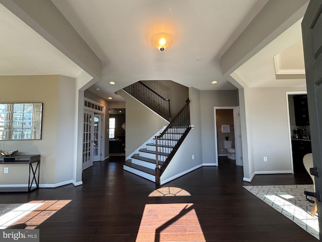 entrance foyer with wood-type flooring, stairs, and baseboards