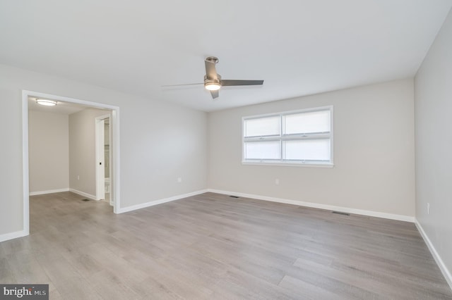 unfurnished room with light wood-type flooring, a ceiling fan, and baseboards