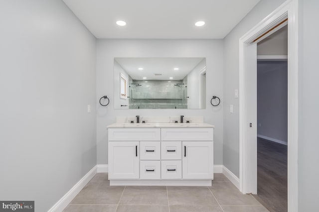 bathroom with double vanity, tile patterned floors, a sink, and a shower stall