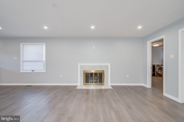 unfurnished living room with recessed lighting, a fireplace, wood finished floors, and baseboards