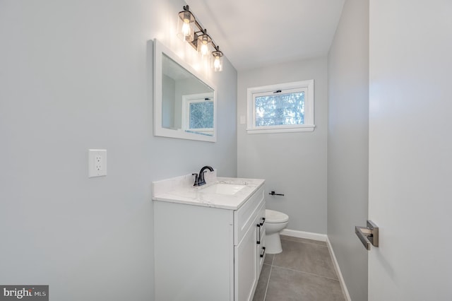 half bath with tile patterned flooring, baseboards, vanity, and toilet