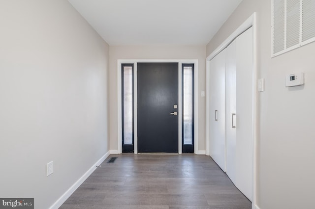 foyer with wood finished floors, visible vents, and baseboards