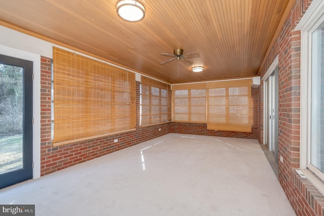 unfurnished sunroom featuring wood ceiling and ceiling fan