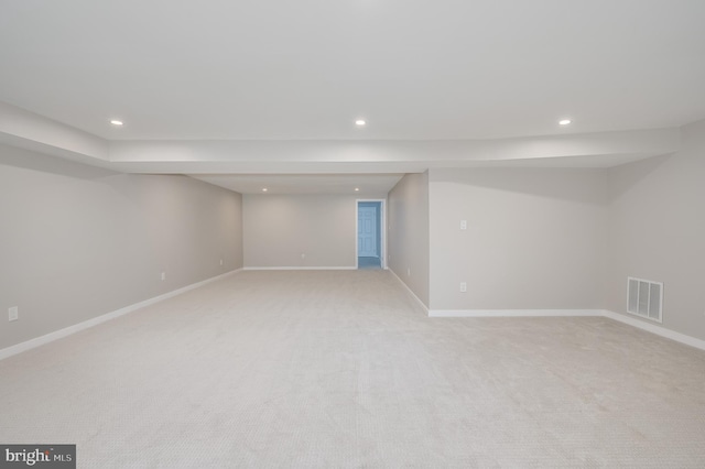 finished basement featuring baseboards, visible vents, light colored carpet, and recessed lighting