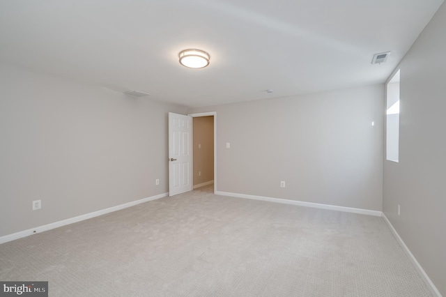 spare room with light carpet, visible vents, and baseboards