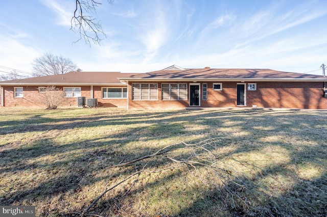 ranch-style house featuring brick siding, a front yard, and cooling unit