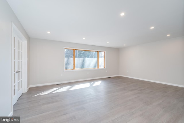 spare room with recessed lighting, light wood-style flooring, and baseboards