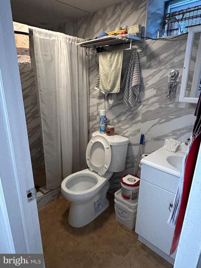 bathroom featuring a stall shower, vanity, and toilet