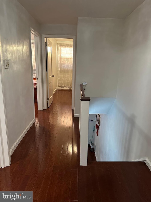 hall with dark wood finished floors and baseboards