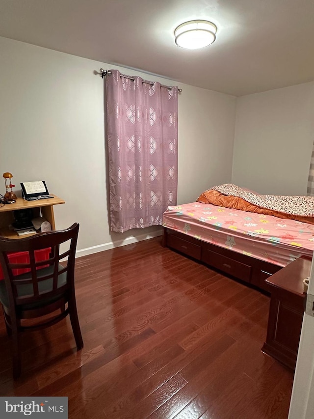 bedroom with baseboards and wood finished floors