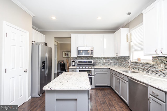 kitchen with appliances with stainless steel finishes, crown molding, a sink, and gray cabinetry