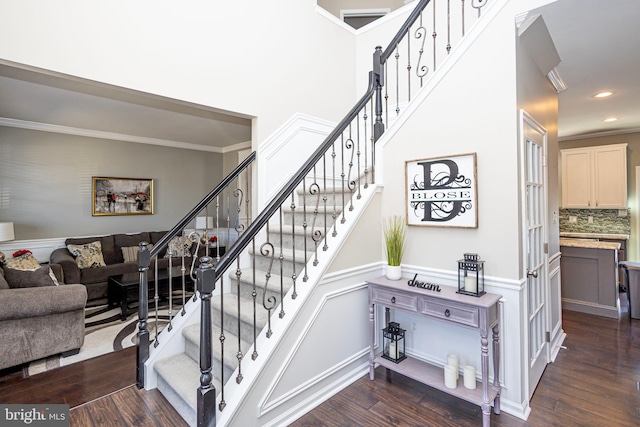 stairway featuring a wainscoted wall, recessed lighting, wood finished floors, and crown molding