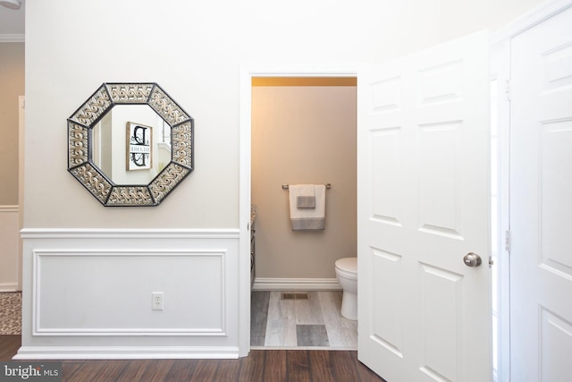 bathroom with visible vents, toilet, and wood finished floors